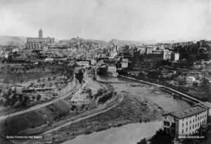 Panoràmica de Manresa, realitzada des de Sant Pau, molt probablement al principi dels anys noranta del segle XIX. En primer terme i a la dreta, la fàbrica de les Roques de Sant Pau; a l'esquerra, la via del ferrocarril del Nord. Al mig, el Pont Vell i la fàbrica Argemí, Vila i Cia, o del Pont Vell, enderrocada a l'agost del 1985. Més enllà i a l'extrem esquerre, la basílica de la Seu, amb el corresponent casquet que coronava originàriament el campanar, i l'església del Carme a la seva dreta. L'edifici de la Cova de Sant Ignasi encara no havia ampliat les seves dependències amb la construcció de la Casa d'Exercicis.
Procedència: Arxiu Comarcal del Bages.