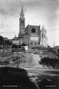 Instantània de la basílica de la Seu tal com era visible des de la plaça de la Reforma vers la meitat dels anys vint del segle passat. Cal observar que el nou pòrtic de la façana principal encara no ha estat construït, però sí que s'havia remodelat el campanar i s'havia aixecat el nou baptisteri. Al peu de la torre-campanar, es pot veure la capella dels favets o de la Puríssima.
Procedència: Arxiu Francesc Villegas i Martínez
