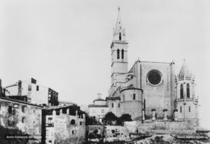 Instantània de la basílica de la Seu tal com era visible des de la plaça de la Reforma vers la meitat dels anys vint. Cal observar que el nou pòrtic de la façana principal encara no ha estat construït, però sí que s'havia remodelat el campanar i s'havia aixecat el nou baptisteri. Al peu de la torre-campanar, es pot veure la capella dels favets o de la Puríssima.
Procedència: Arxiu Jaume Pons i Agulló