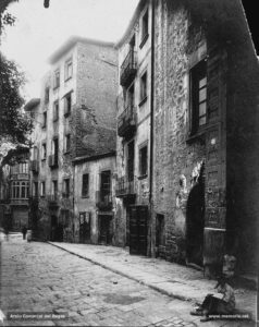 Imatge inèdita del carrer de les Piques i de les cases que foren enderrocades al tombant de segle XX per a l'arranjament del sector de la Reforma (entre les quals, ca la Mònica). Al fons es perfila la casa Llissach, on l'any 1902 el notari Lluís de Travy i de Còdol va traslladar l'arxiu de protocols notarials.
Procedència: Col·lecció Jaume Blanch i Carreras (Fotografia de Francesc Blanch i Pons)