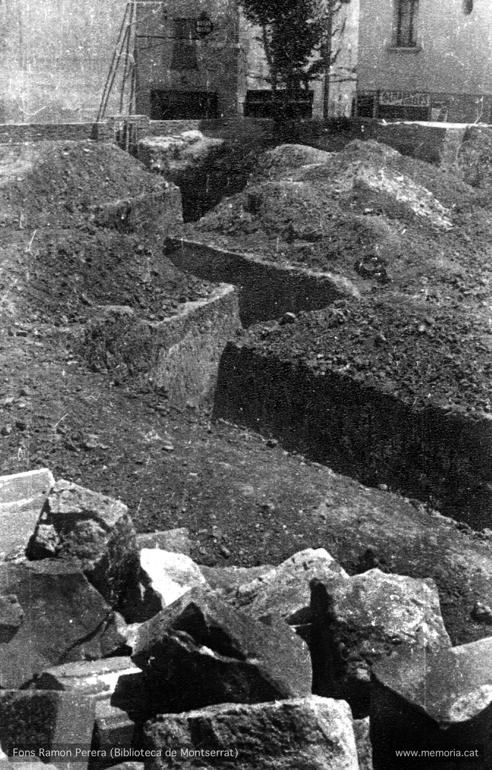 Vic. Juliol 1938. Solar del convent enderrocat de Santa Clara.
Refugi de trinxera en ziga-zaga. Surt a la cruïlla dels carrers Trinquet i Sant Sebastià, amb els carrers Fusina i Sant Fidel. En aquest últim carrer es pot llegir amb dificultat el cartell del Colmado Cubeles. (Cartera: 12 Foto: 309).